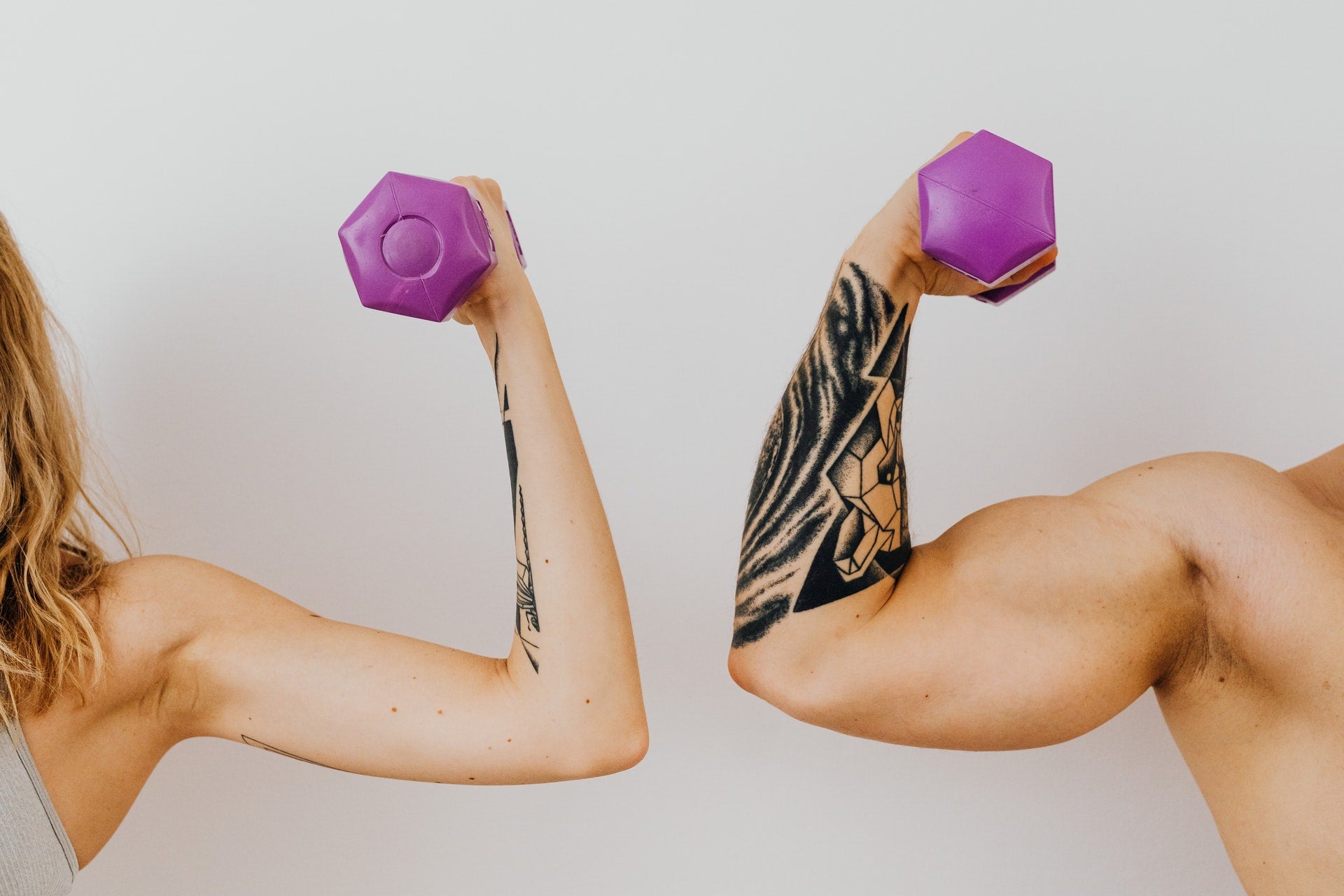 man and woman showing their bicep while holding burbles